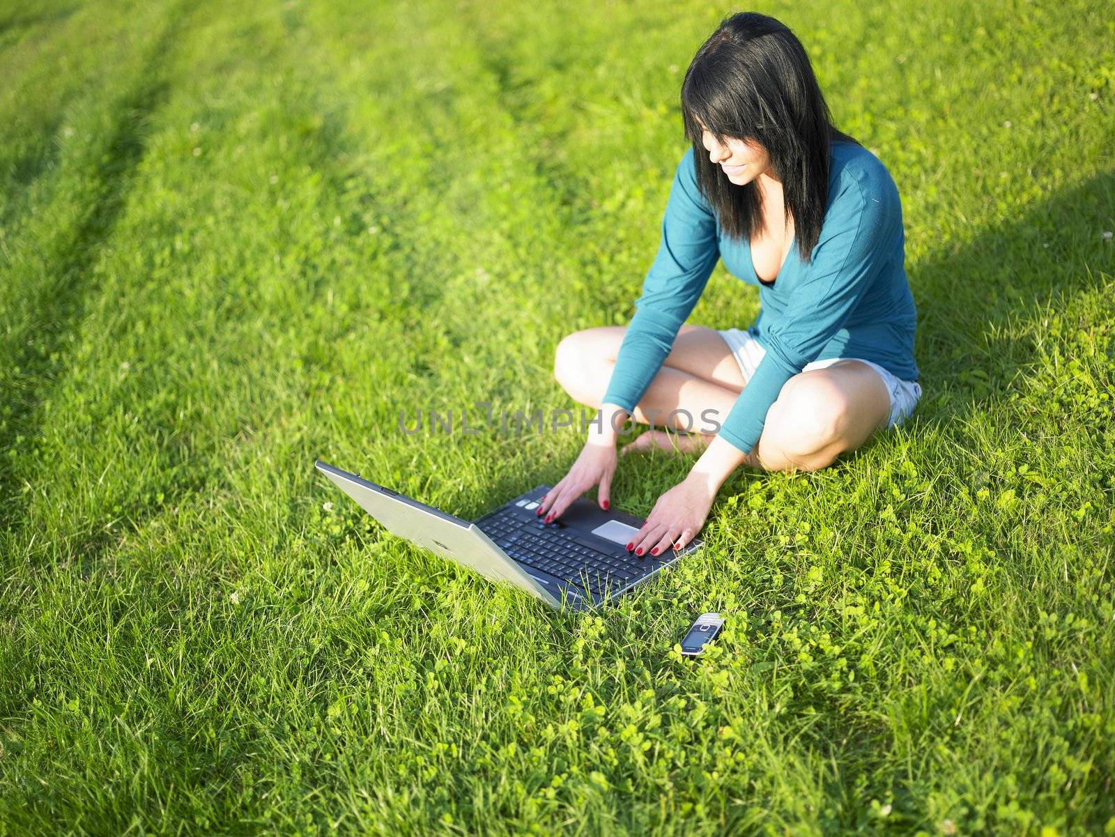 Young woman using laptop in park