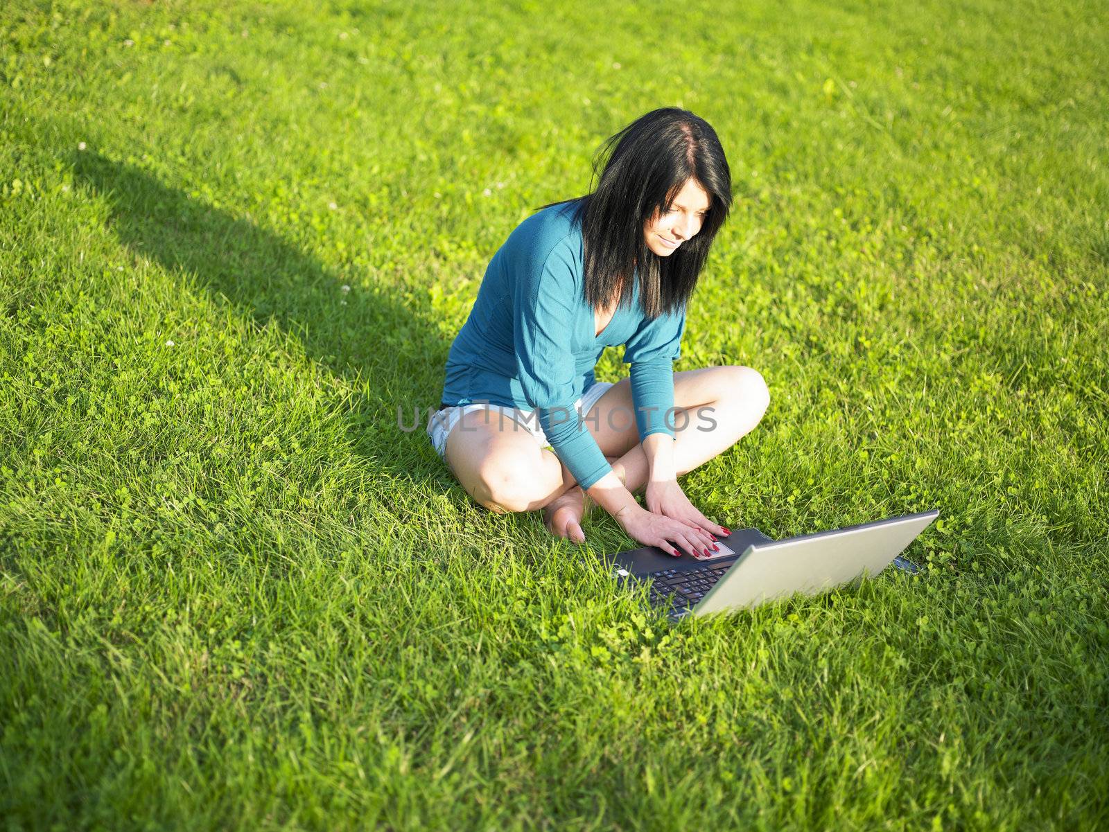 Young woman using laptop in park