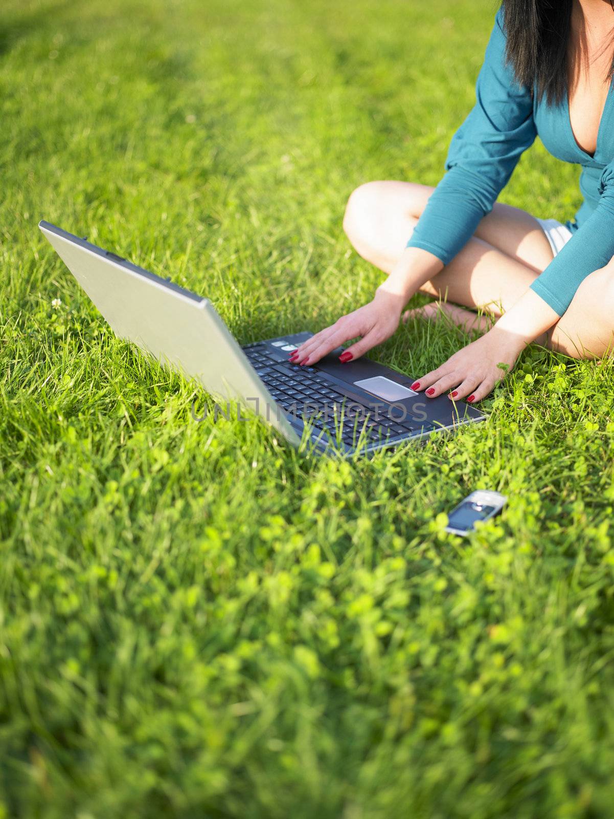 Young woman using laptop in park