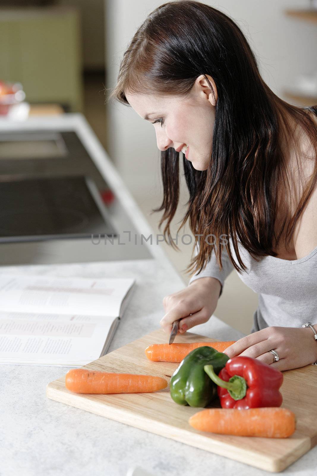 Woman reading cookery book by studiofi