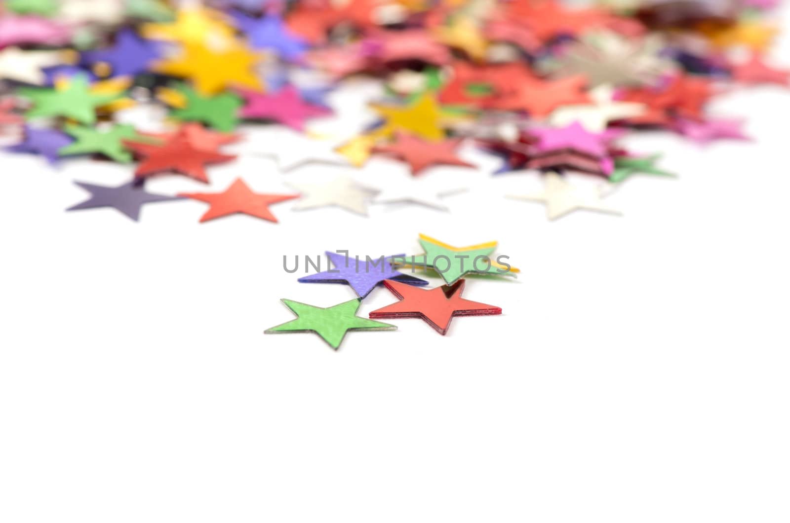 Christmas decoration of colored confetti stars against white background
