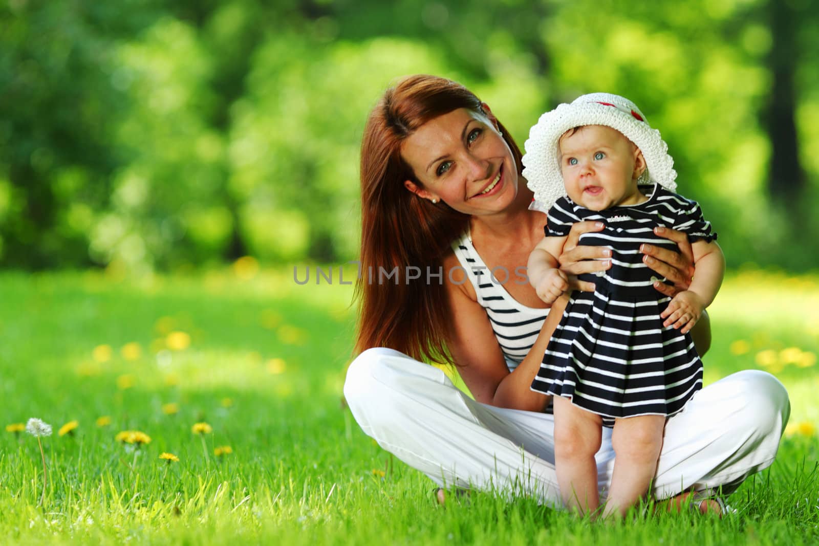 Happy mother and daughter on the green grass