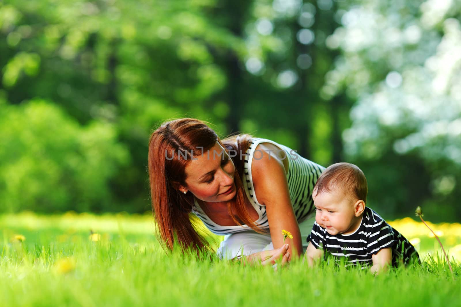 Happy mother and daughter on the green grass