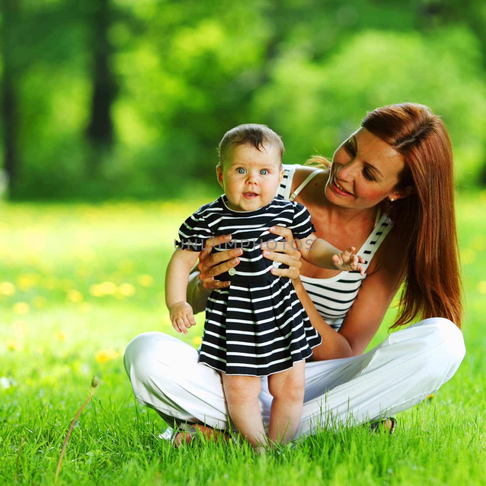 Happy mother and daughter on the green grass