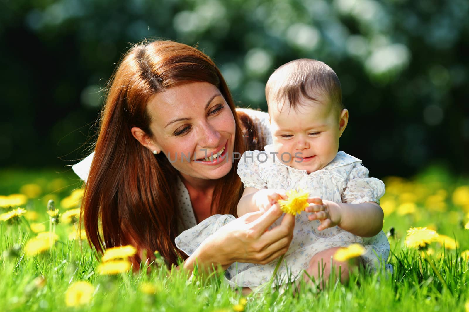 Happy mother and daughter on the green grass