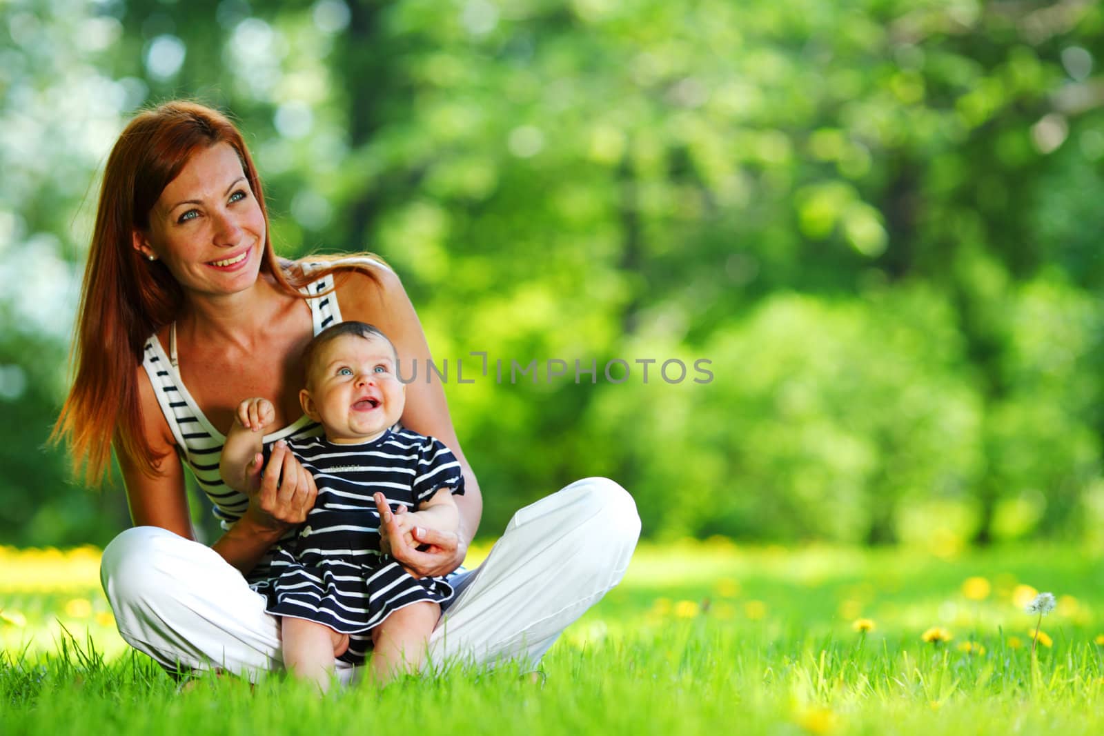 Happy mother and daughter on the green grass