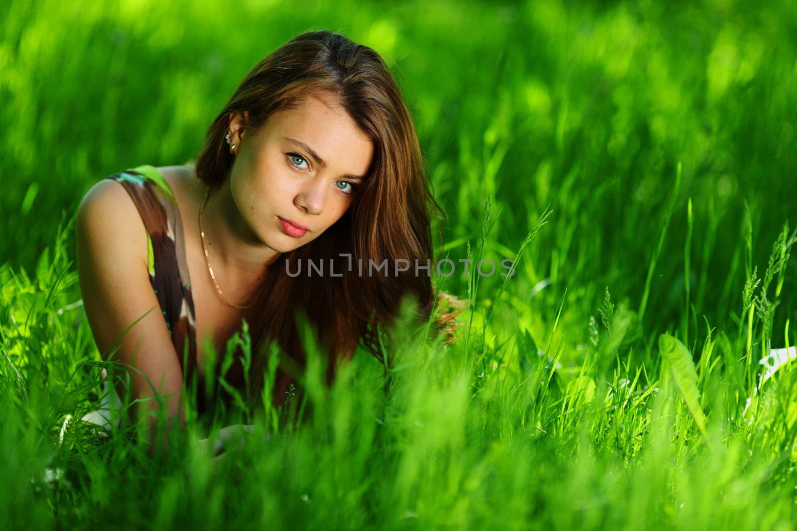 brunette lying on green grass