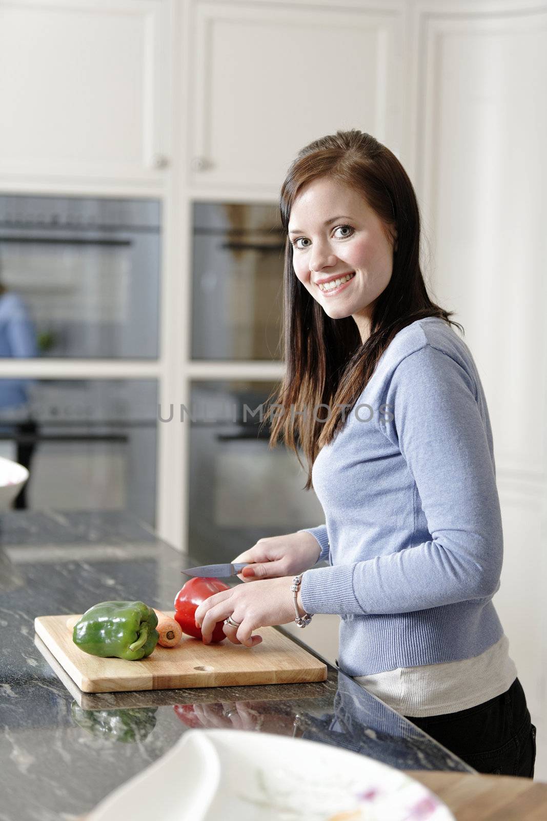 Woman preparing a meal in the kitchen by studiofi