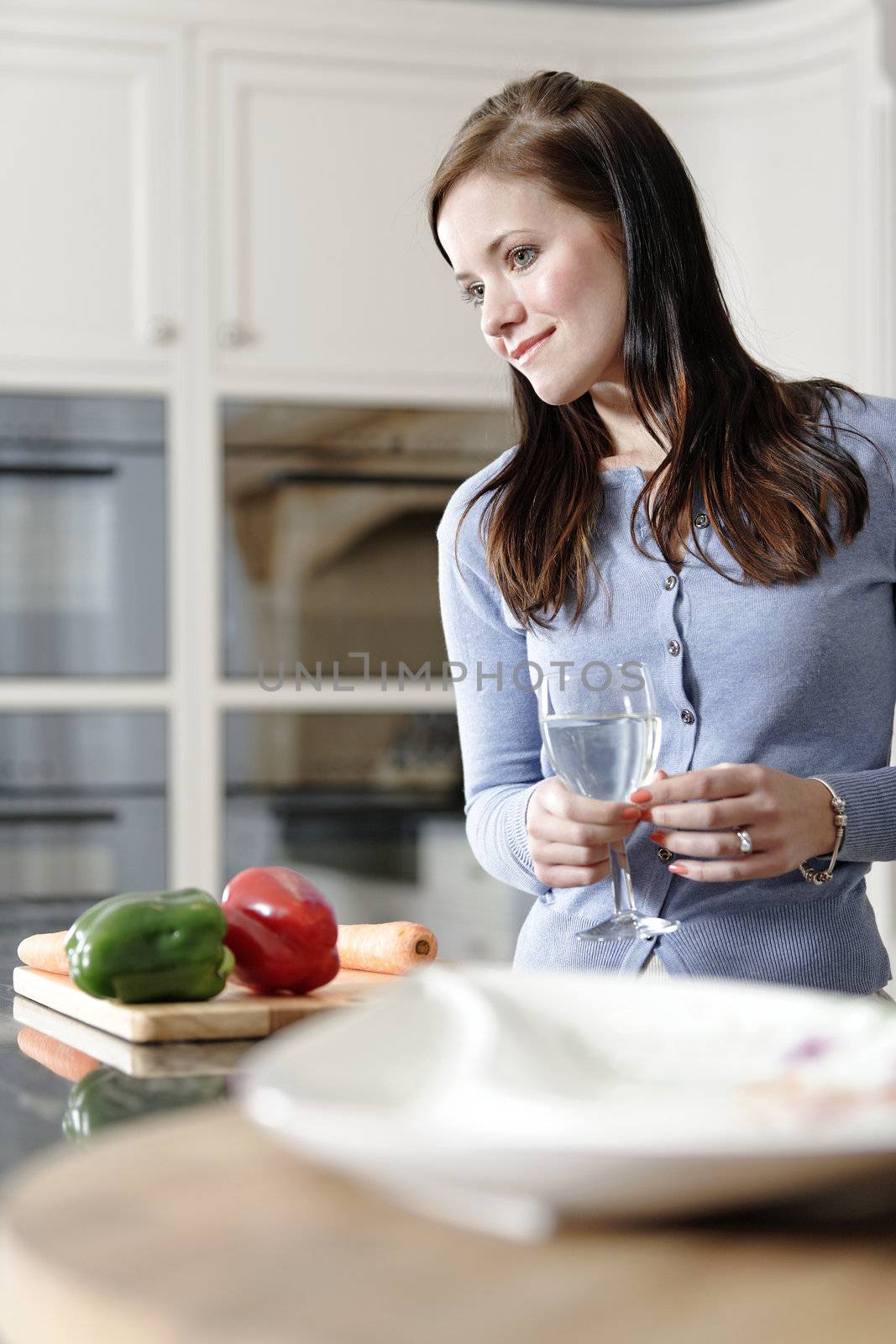 Woman preparing a meal in the kitchen by studiofi