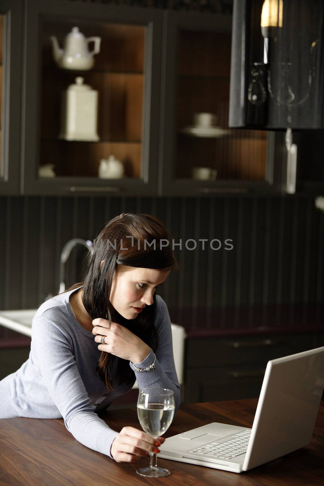 Woman on a laptop in kitchen by studiofi