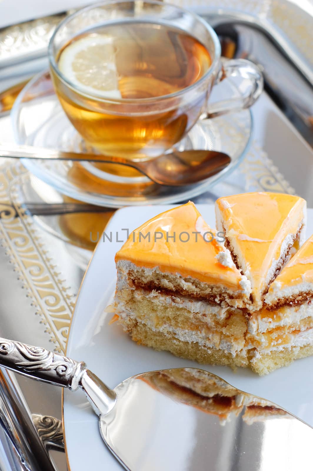 Piece of cake with apricot and tea on tray