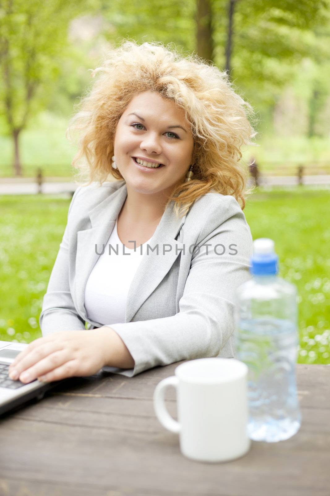 Woman using laptop in park by adamr