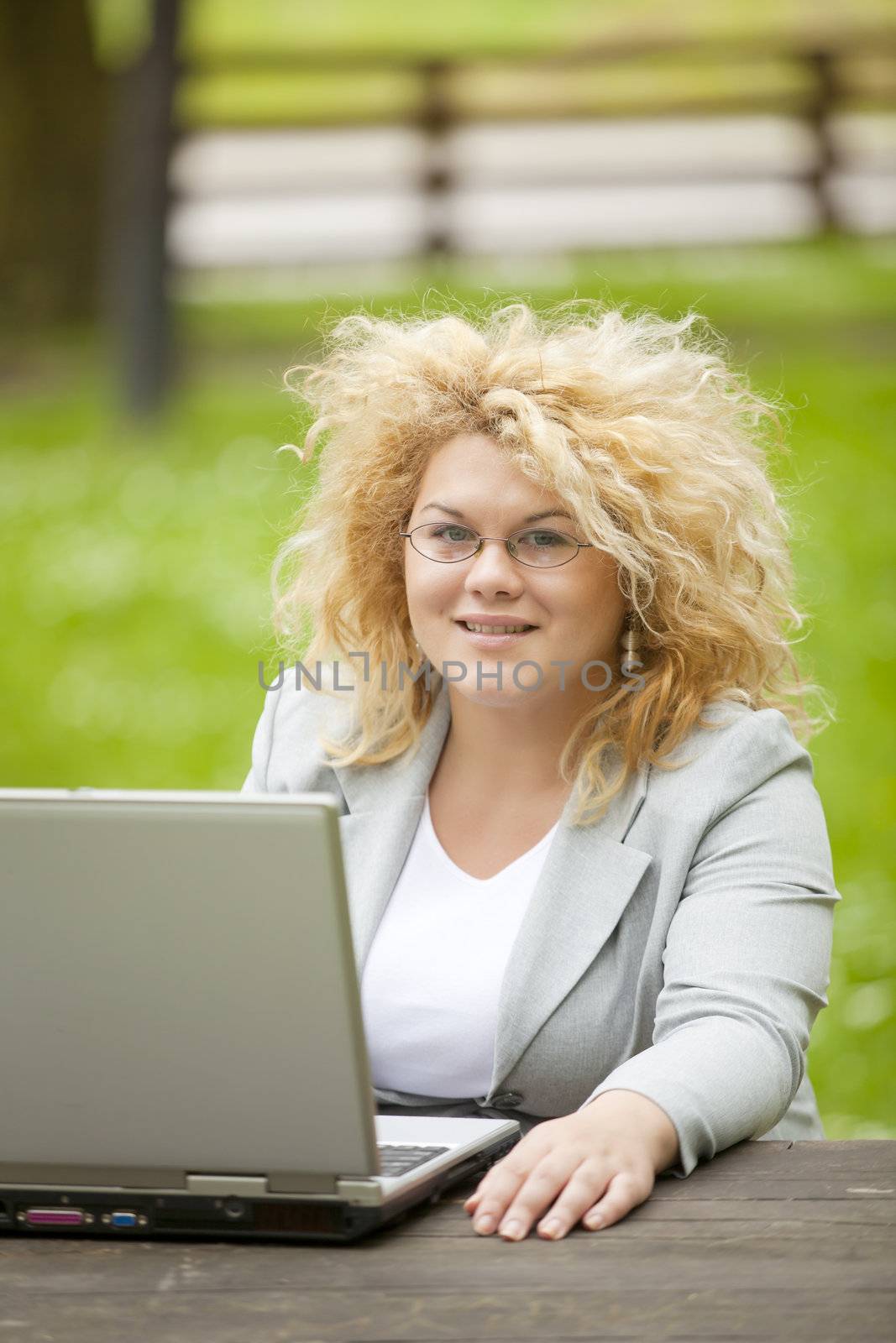 Woman using laptop in open office by adamr