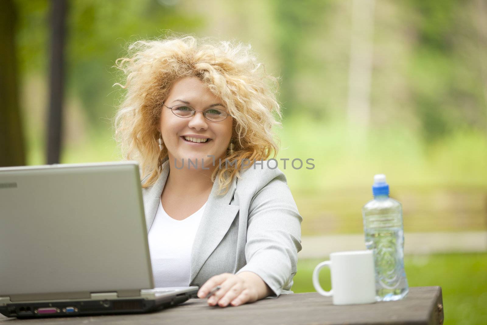 Happy Business Woman using laptop in park by adamr