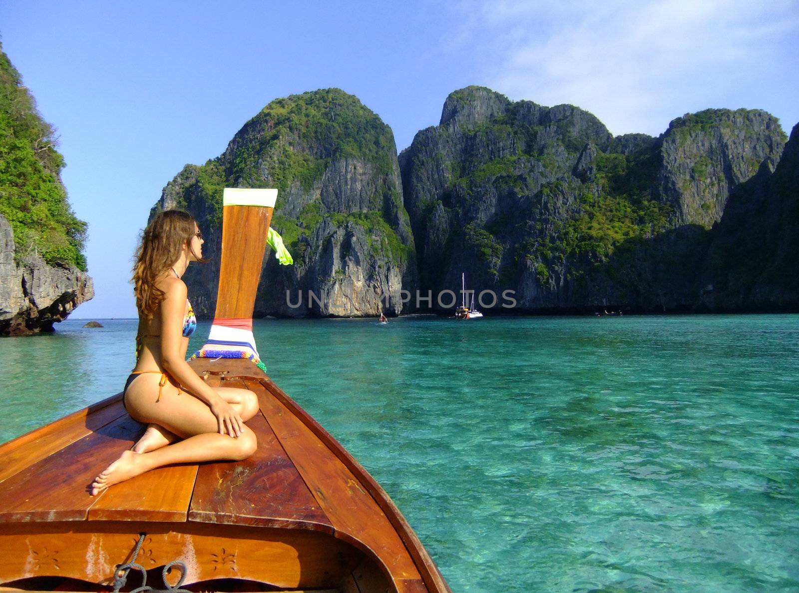 Young woman in bikini sitting on a stern of longtail boat, Phi P by donya_nedomam