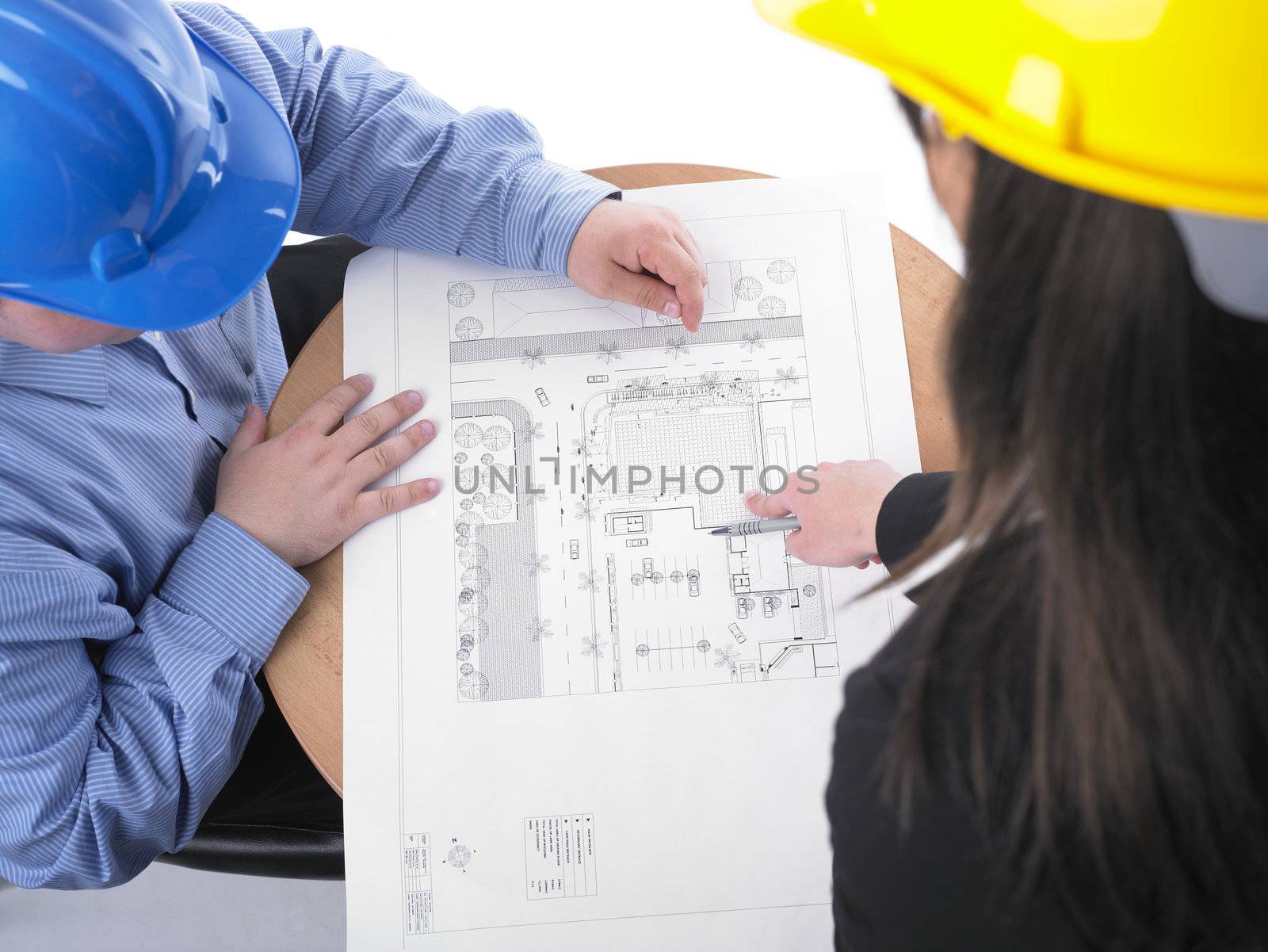 Two architects with hard hat and plan on meeting by adamr