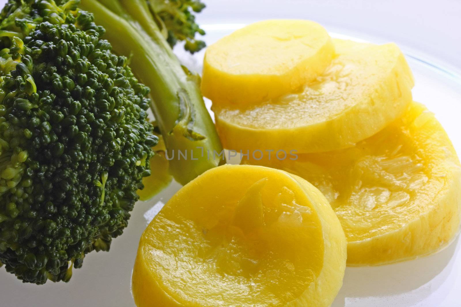 Broccoli and squash on plate, isolated.