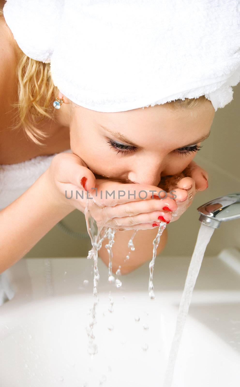 beautiful young woman washing her face at home in the bathroom