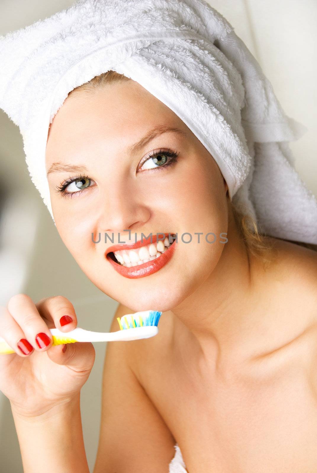 beautiful happy young woman brushing teeth at home in the bathroom