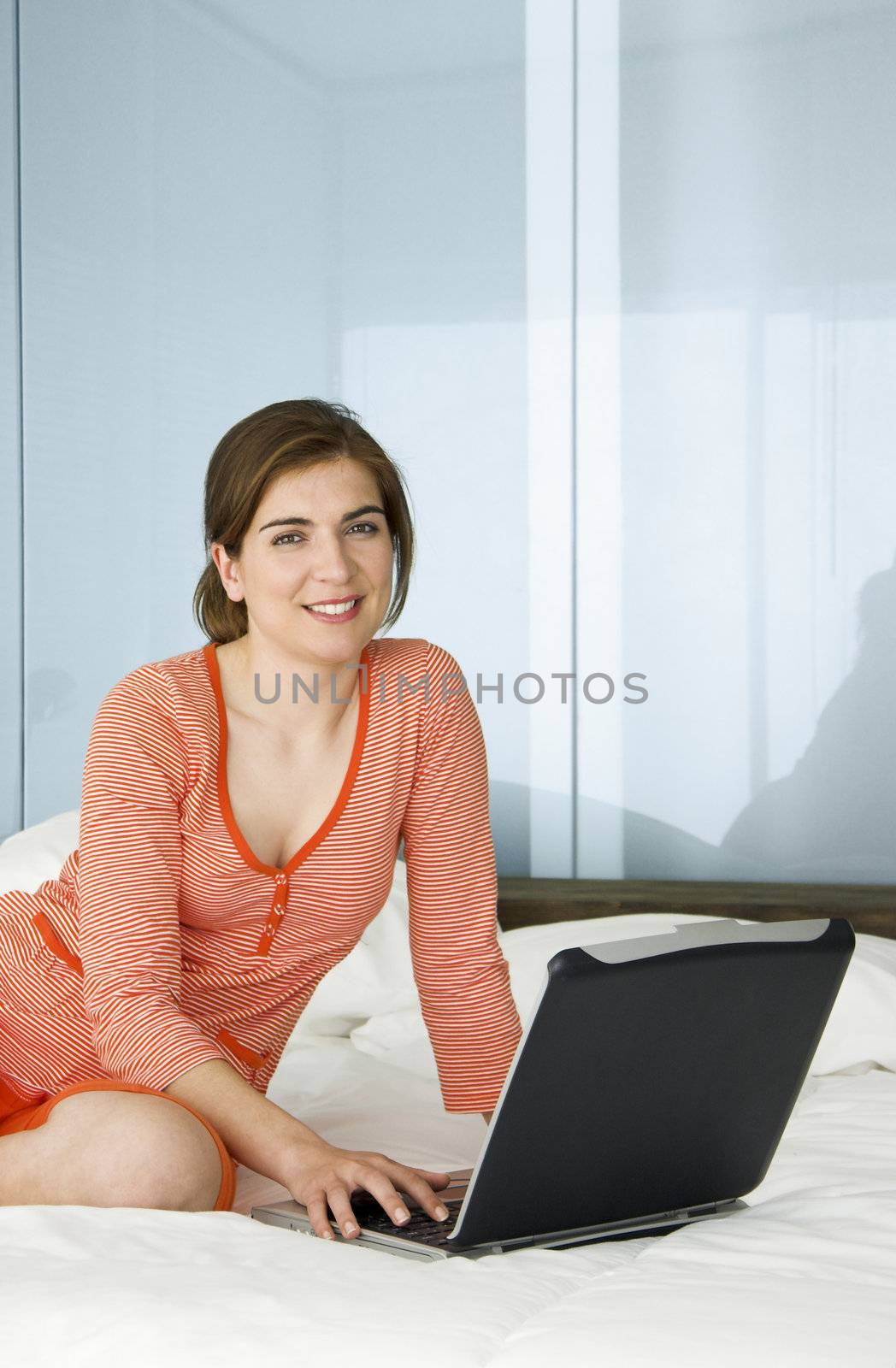 Beautiful woman in pajama working on a laptop
