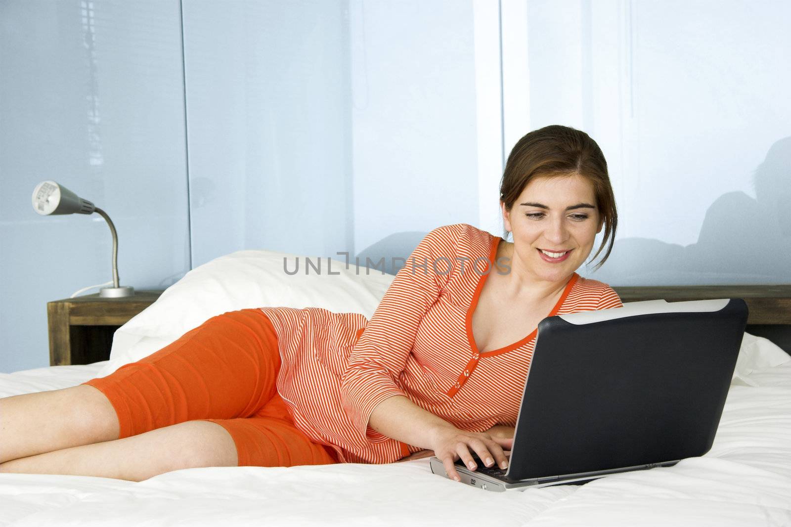 Beautiful woman in pajama working on a laptop