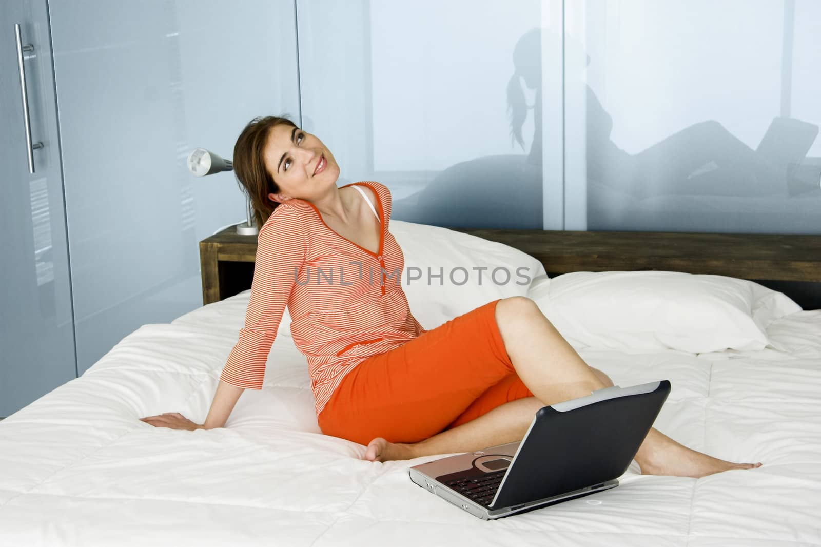 Beautiful woman in pajama relaxing with a laptop