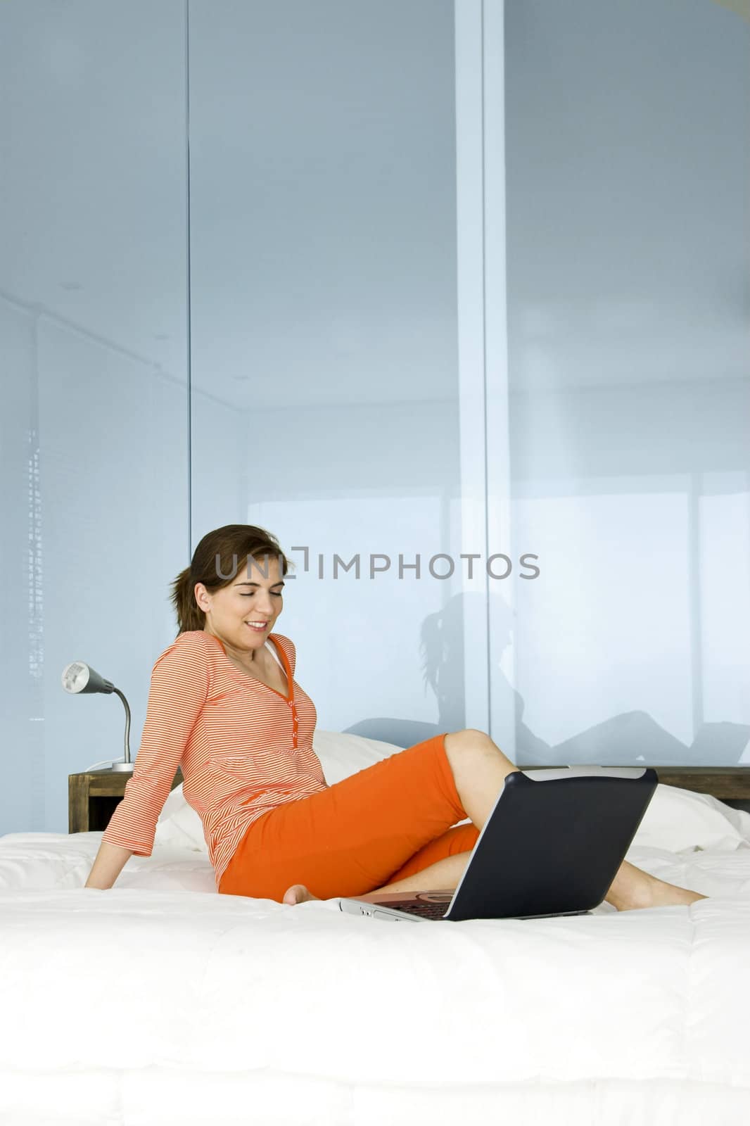 Beautiful woman in pajama relaxing with a laptop