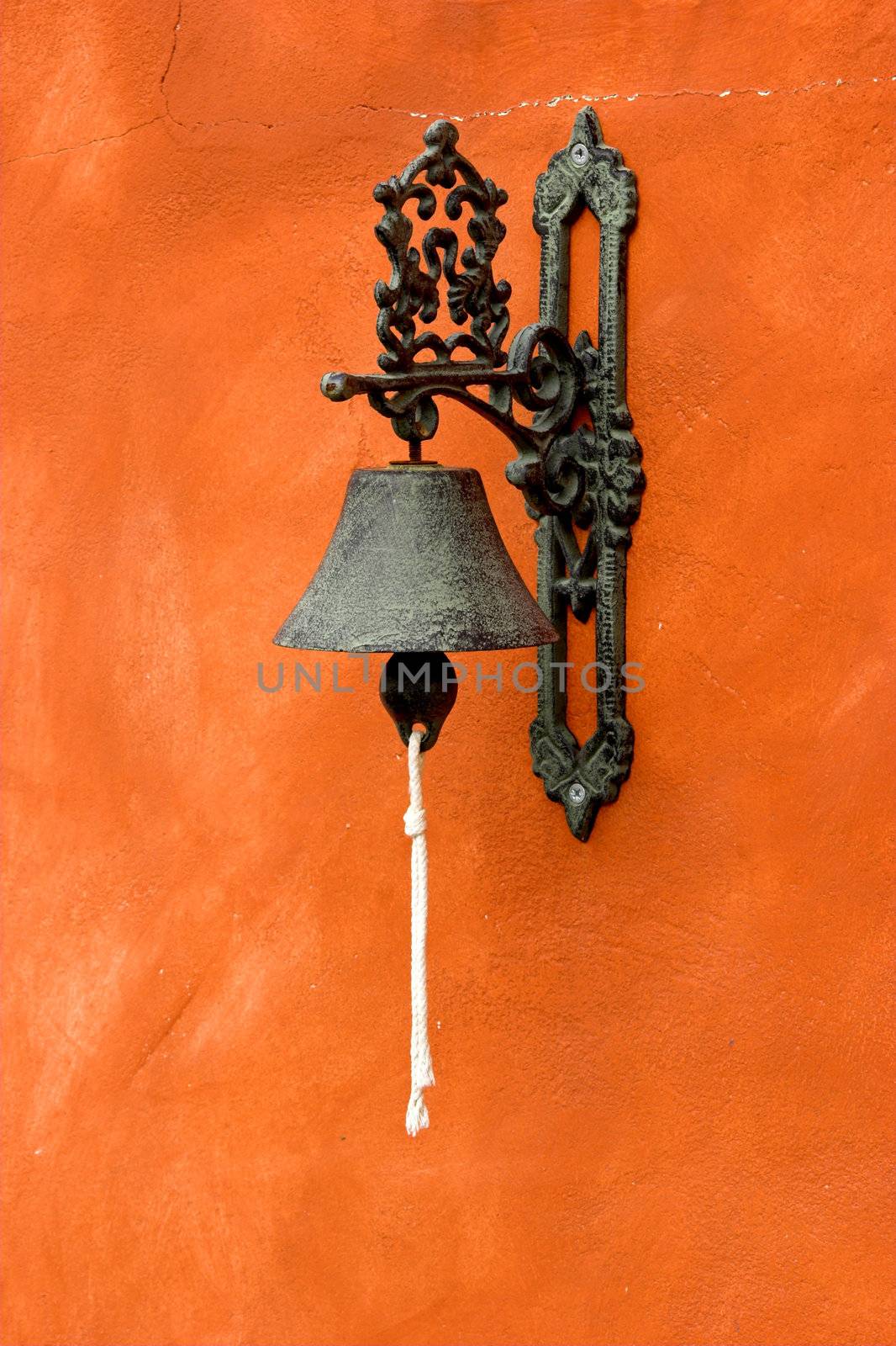 Old vintage bell on a orange wall