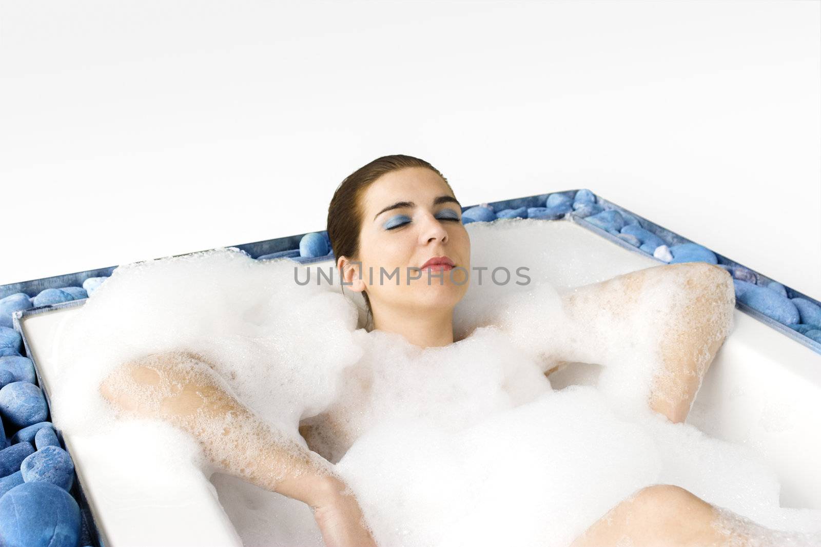 Young woman enjoying the bath-foam in the bathtub. 
