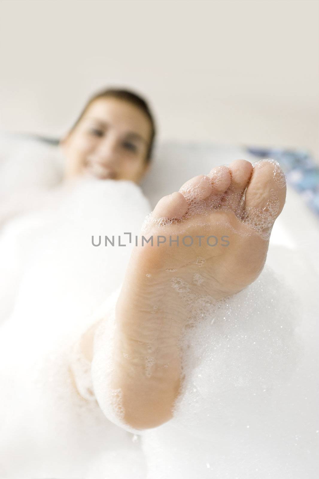 Young woman enjoying the bath-foam in the bathtub. 