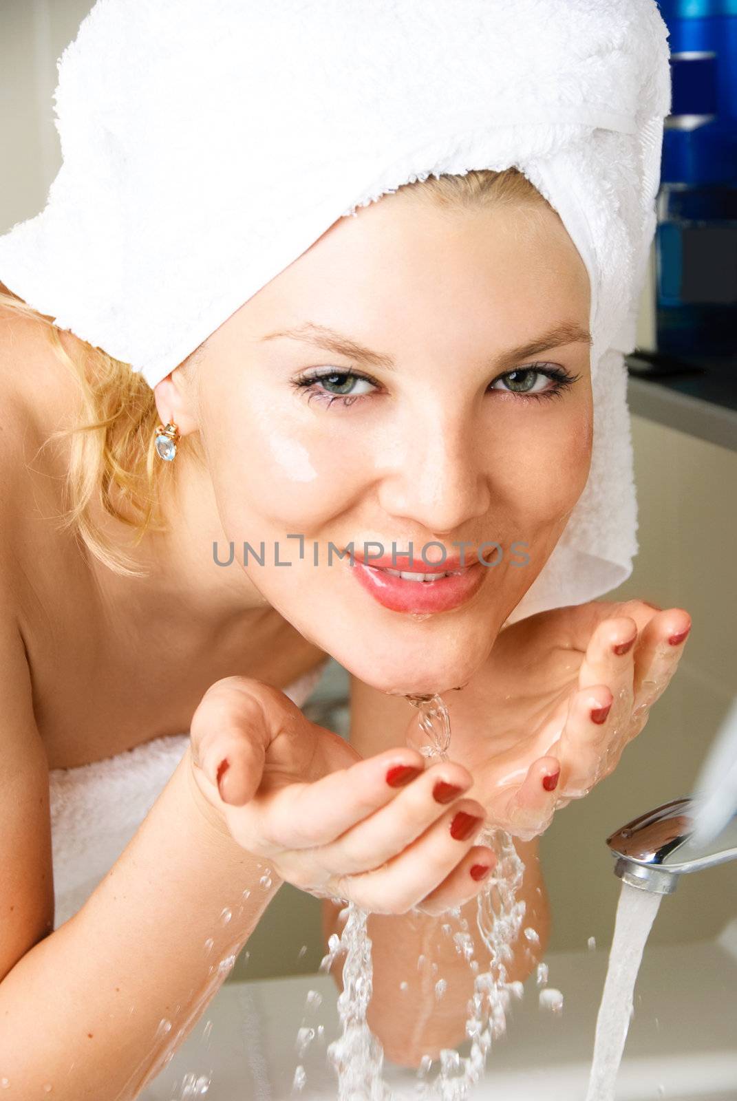 beautiful happy woman washing her face in the bathroom