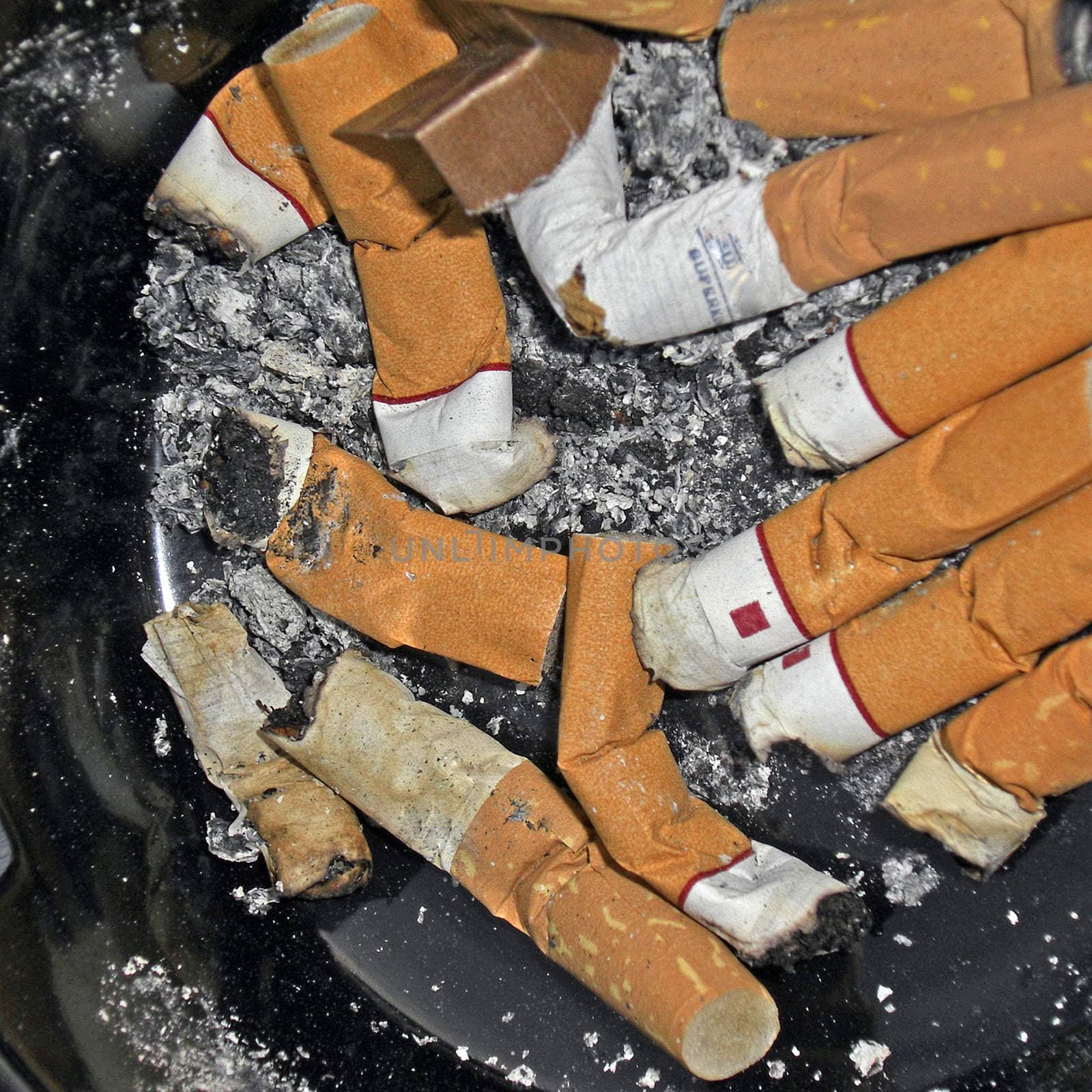 Cigarette butts in an ash tray.