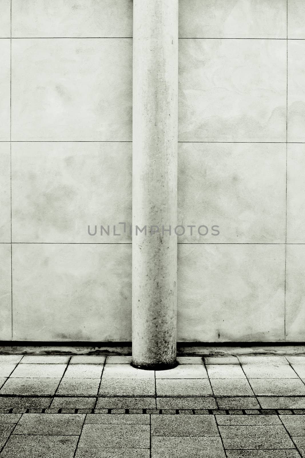 Modern stone pillar against a wall in monochrome