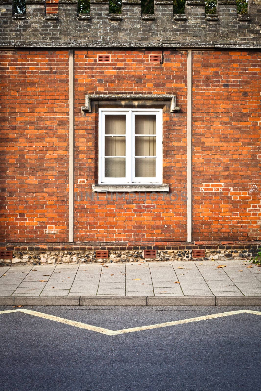 A window in a red brick wall in an english building