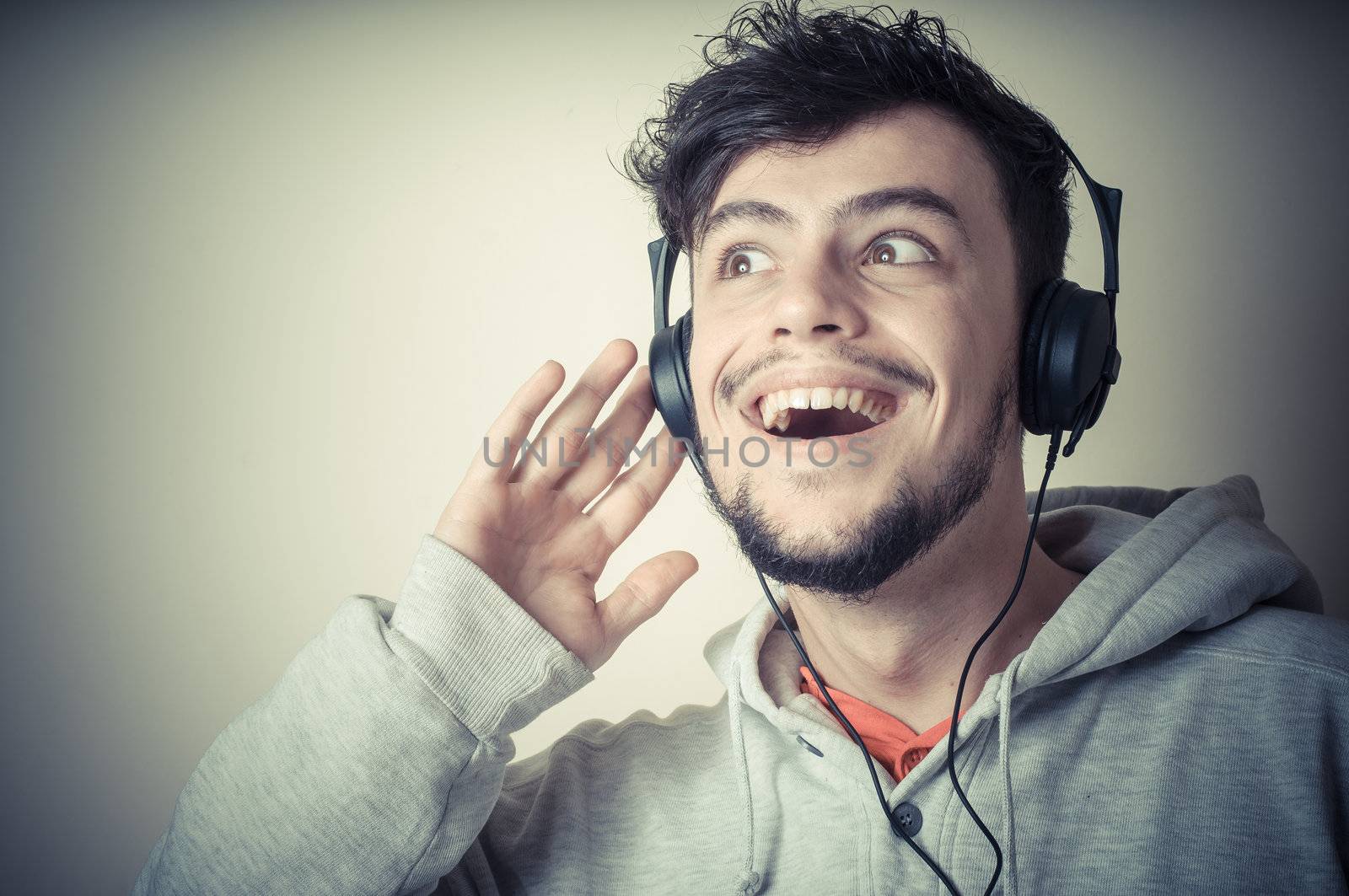 boy with sweatshirt and headphones on gray background 