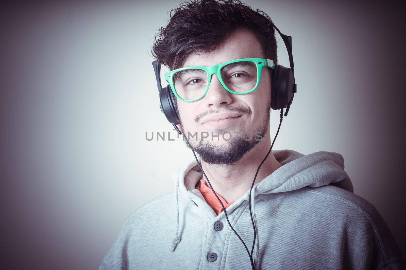 boy with sweatshirt and headphones on gray background 