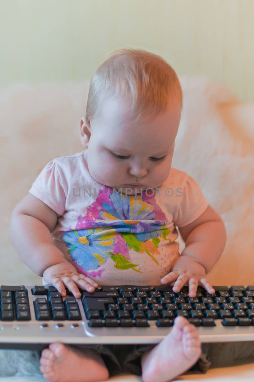 Portrait of baby in t-shirt with keyboard