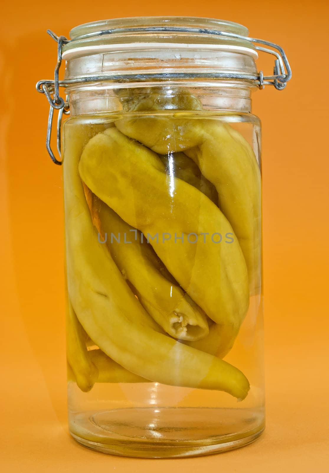 Chili peppers marinated in the glass jar isolated on the white background