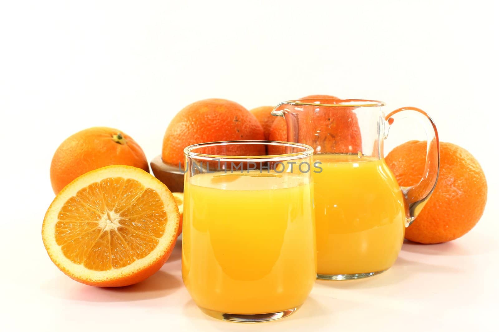 a glass of orange juice and fresh oranges