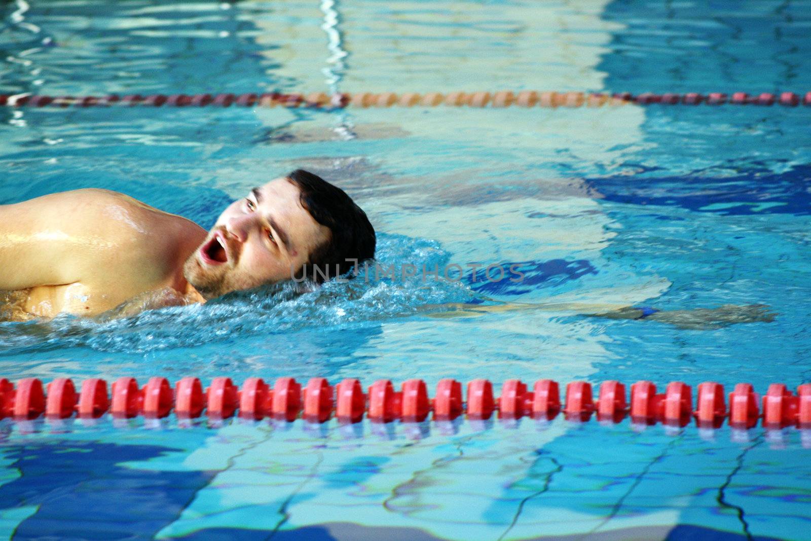 man swims in swimming pool