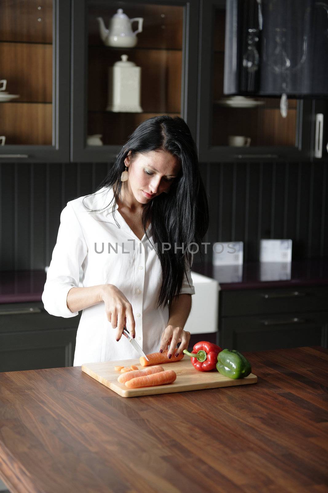 Woman chopping fresh vegetbles by studiofi