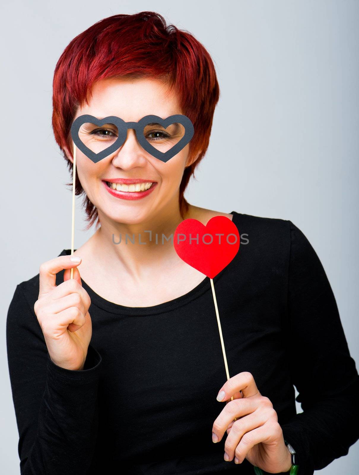young woman with a red paper heart in glasses