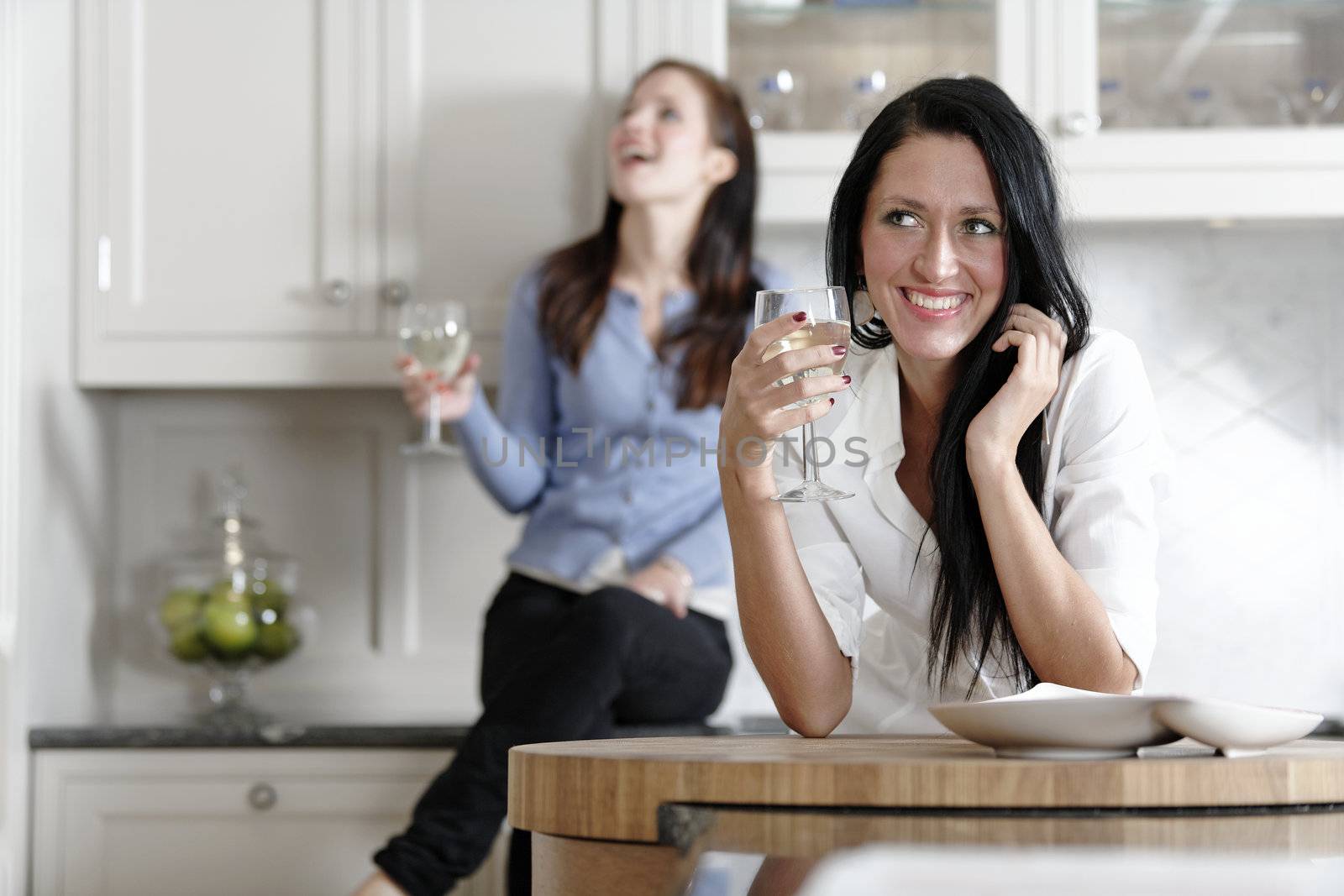 Two friends relaxing in the kitchen by studiofi