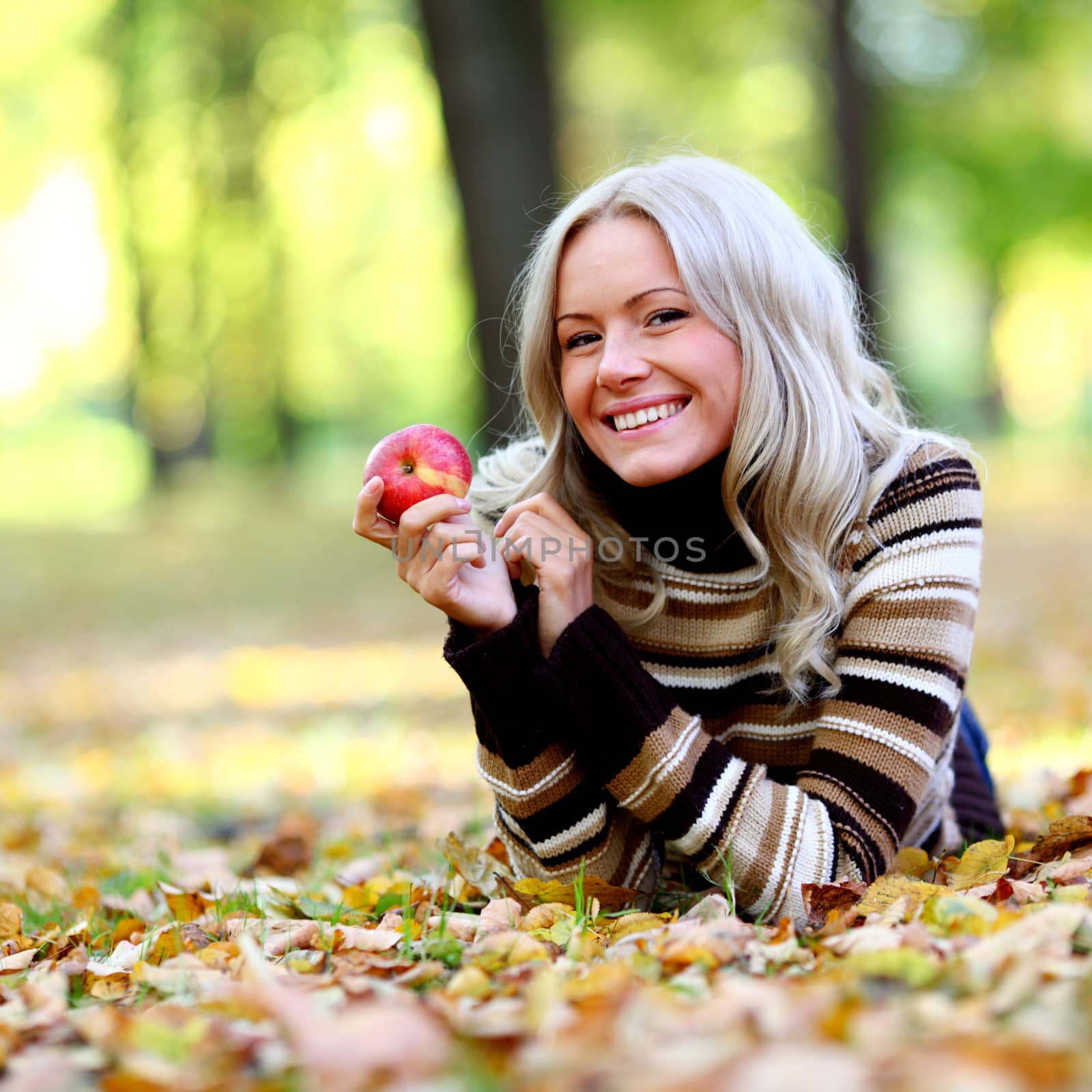 woman with red apple in autumn park