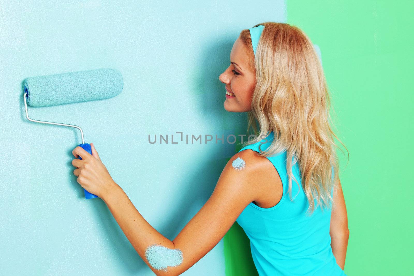 woman paints the wall roller