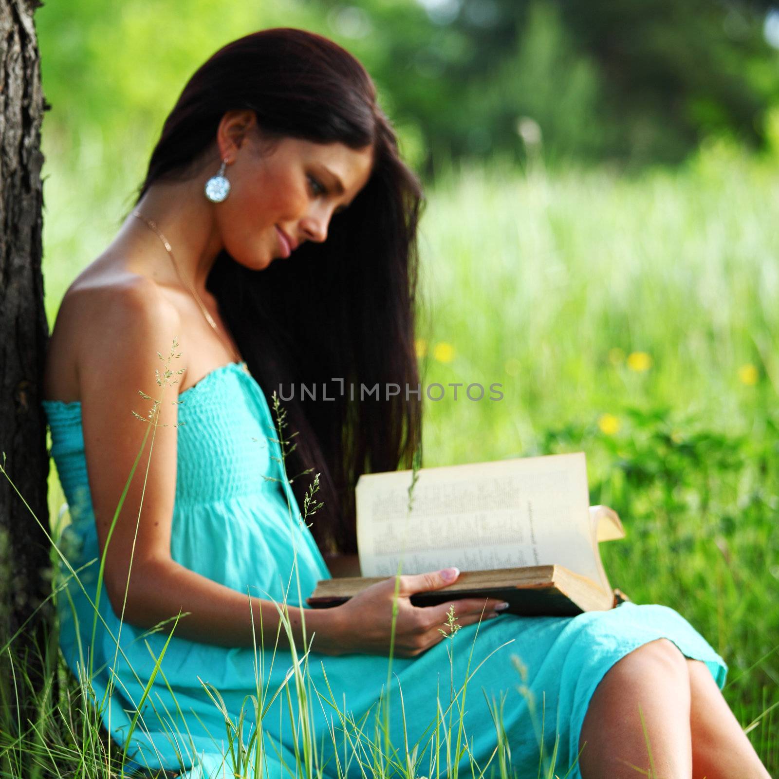 girl with book under big tree