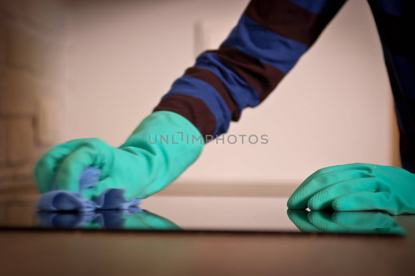 Close-up of human hands polishing the stove