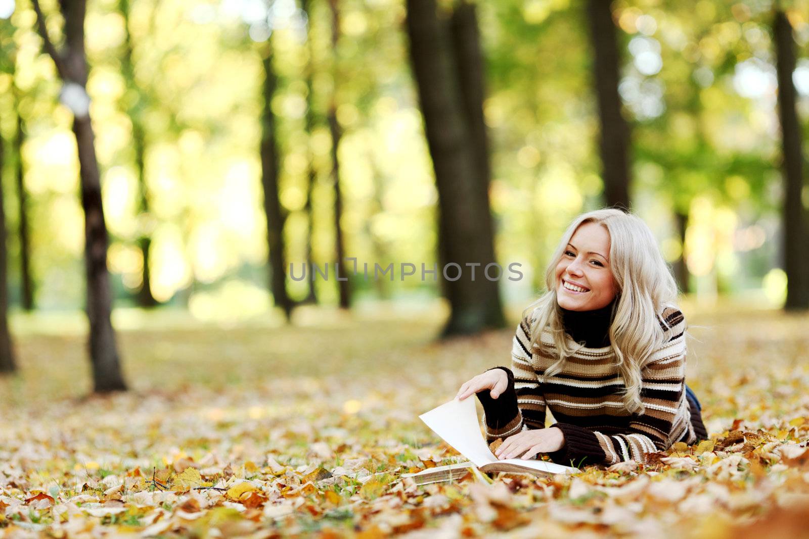 woman read the book in autumn park