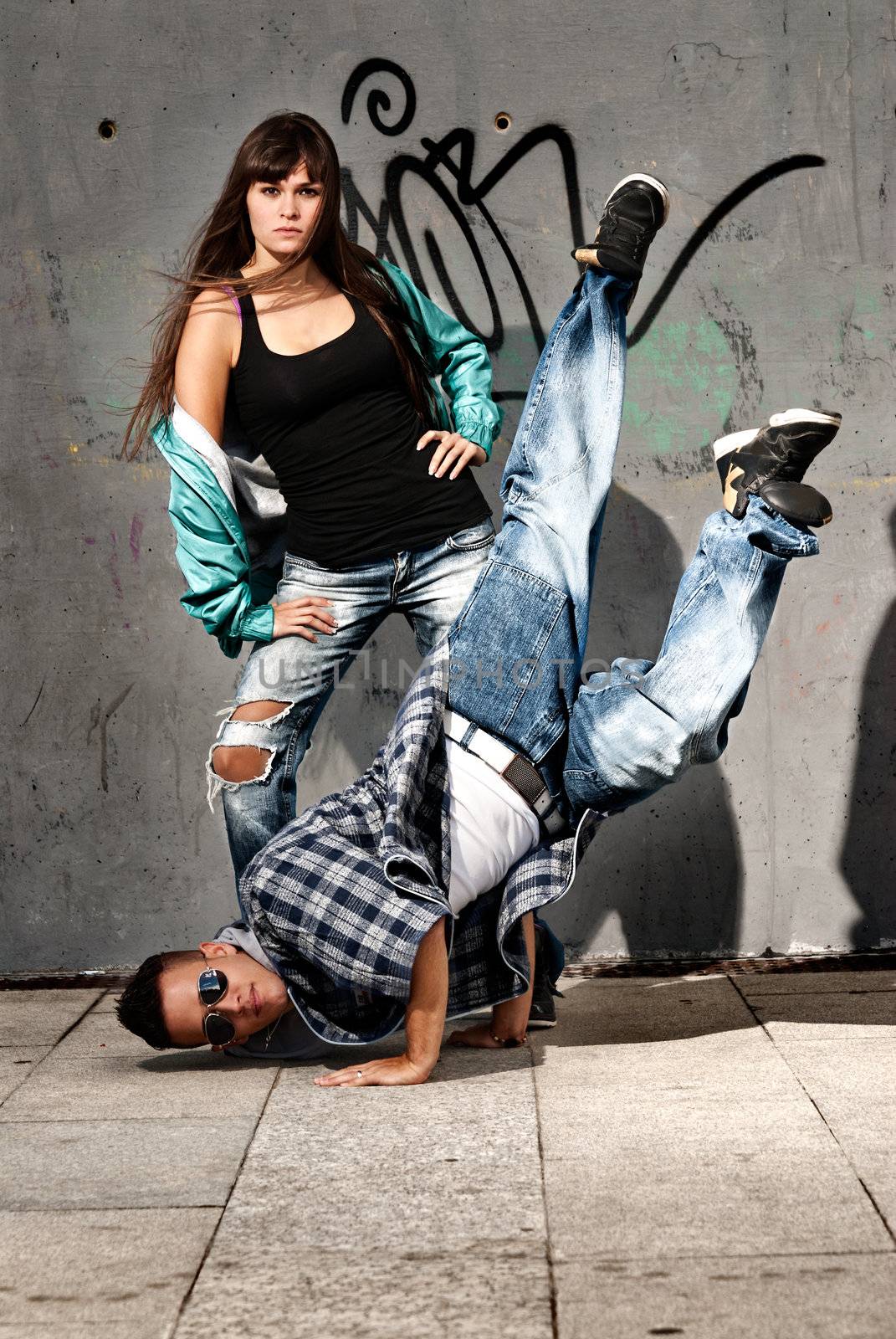 Young urban couple dancers hip hop dancing urban scene by dgmata