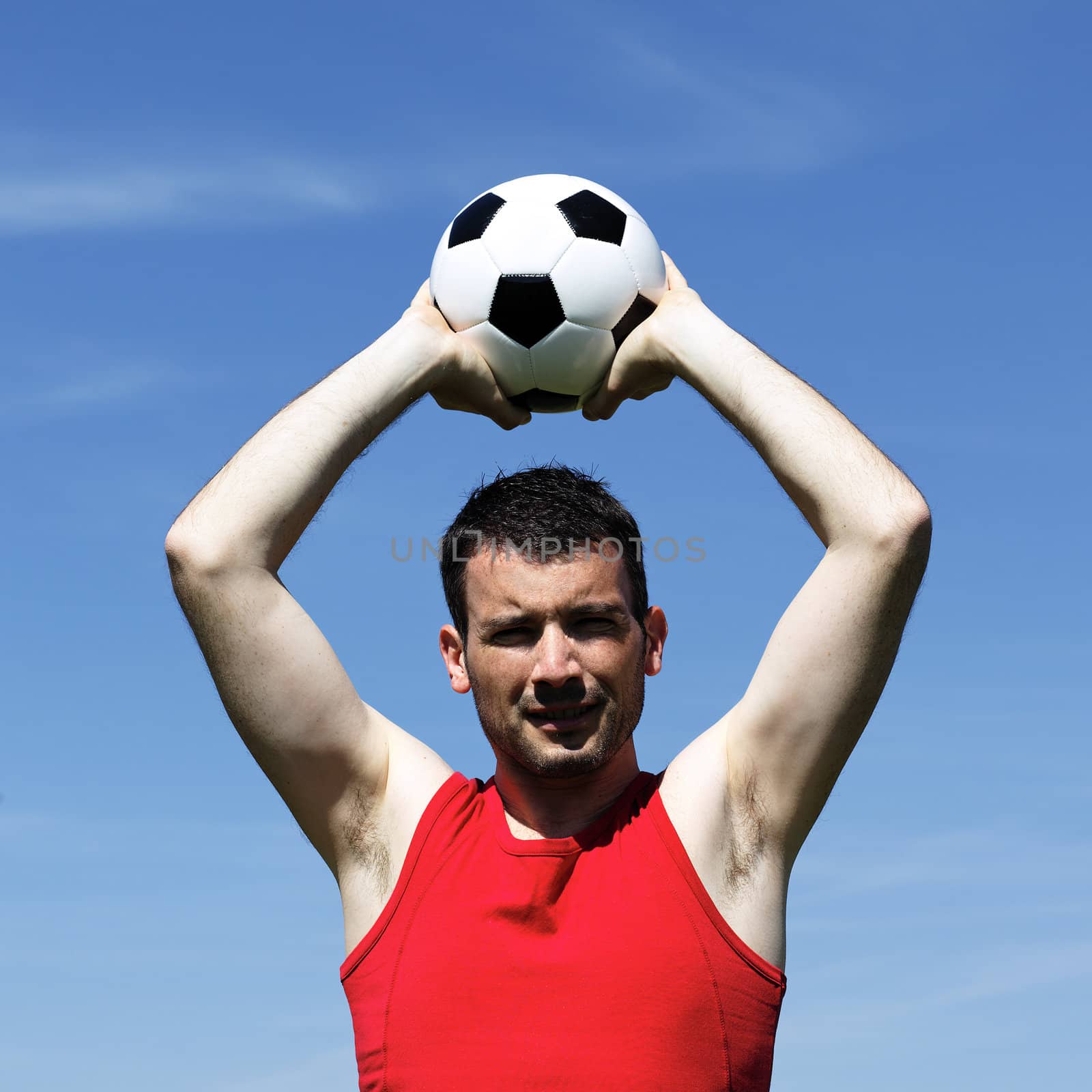handsome man with ball and blue sky in summer